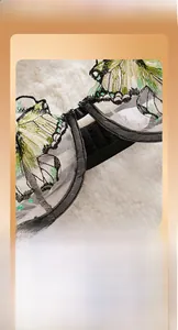 Close-up of white mesh lingerie with delicate green butterfly embroidery and black straps