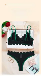 Ensemble de lingerie en dentelle noire et verte avec soutien-gorge et culotte sur fond cadeau