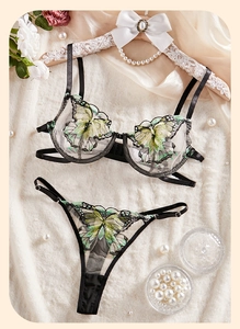 Detail of floral butterfly embroidery on black mesh and satin luxury lingerie set