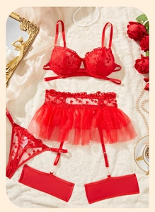Dettaglio del set lingerie in pizzo rosso con ricamo a cuore e giarrettiera a rete