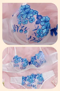 Detailed blue floral embroidery on white lace lingerie set with a soft tulle backdrop