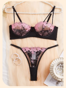 Close-up of pink floral embroidery on sexy black lace bra and panty lingerie set