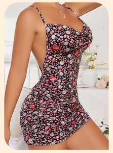 Detail of ruched side design on black floral mini dress with thin shoulder straps