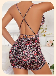 Close-up of ruched floral backless mini dress with cross thin straps in black and pink