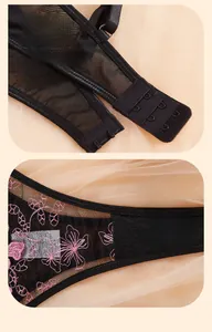 Detailed close-up of pink floral embroidery on sheer black mesh lace bra with back hook eye