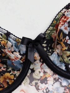 Détail macro du corset en mesh fleuri avec dentelle noire et un nœud en satin