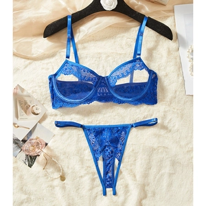 Set lingerie in pizzo blu reale con reggiseno a ferretto e perizoma su sfondo decorato