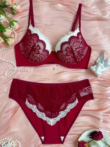 Detailed view of burgundy lace lingerie set with white floral embroidery on satin background