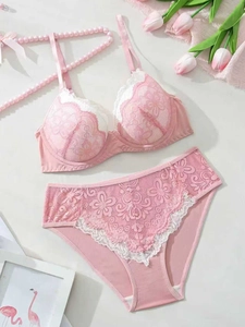 Flat lay of pink floral lace bra and high-waisted panties set with elegant tulip decor