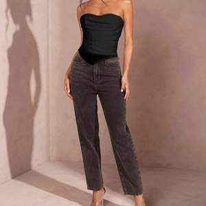 Sexy black pleated tube top with bone corset detail paired with washed grey denim jeans