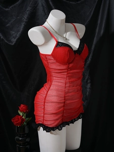 Detail of red sheer mesh nightgown with black lace trim and ruffled hem on mannequin