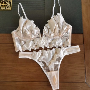Detailed view of white floral embroidery and delicate lace on the sheer bralette set