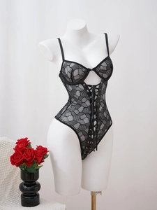 Détail d'un body sexy en dentelle noire avec ruban lacé style corset et résille florale