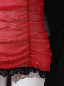Detail of red pleated fabric with subtle shimmer and black mesh ruffle hem trim