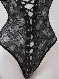 Détail d'un body en maille noire avec laçage frontal et œillets métalliques argentés
