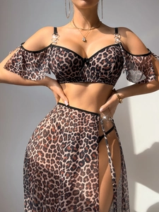 Detail of leopard print crop top with metal ring buckle and high slit wrap skirt set