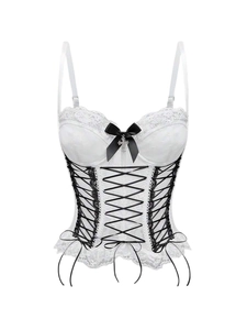 Macro shot of white lace corset detail featuring black ribbons and a metal cross charm