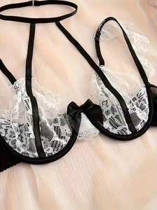 Dettaglio di lingerie in pizzo bianco e nero con fiocco di raso e cinturino al collo