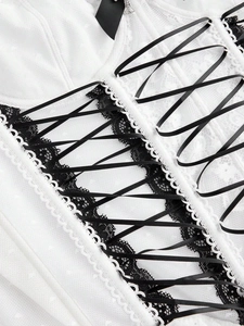 Detailed macro view of black lace-up satin ribbon and bow on a white corset tank top