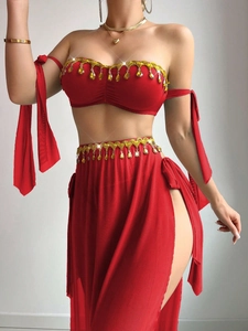 Detail of red mesh dance top and high slit skirt with gold leaf tassels and amber stones