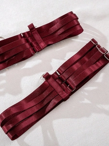 Detailed close-up of burgundy straps with silver metal adjusters on lingerie set