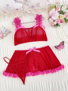 Detail view of red mesh lingerie set with pink ruffle lace and delicate bow accents