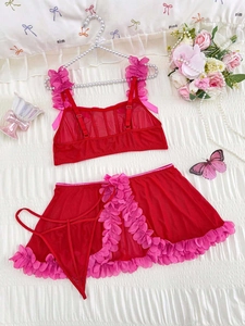 Detailed flat lay of a red three-piece mesh lingerie set with pink ruffle lace trim