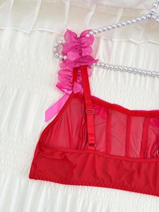 Detail of red mesh lingerie featuring ruffled edges and a heart-shaped cutout design