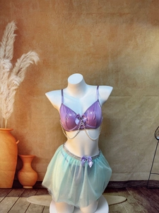 Detail of purple metallic bra with pearl chains and green mesh tutu on a mannequin