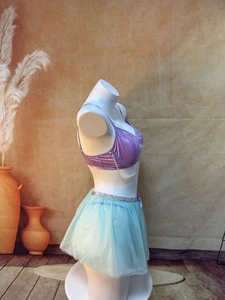 Detail of metallic purple top with pearl chains and mint green layered mesh skirt
