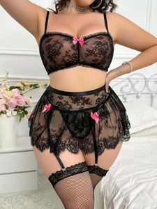 Détail d'un ensemble de lingerie en dentelle noire avec nœuds roses et bas résille