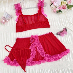 Three-piece red mesh lingerie set with pink ruffles and skirt on white fabric background
