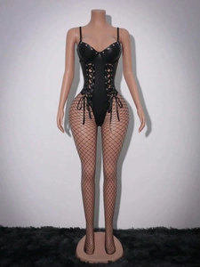 Détail d'un body noir en simili cuir avec laçage frontal, œillets métalliques et bas résille