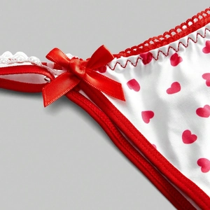 White bikini bottoms with red heart print, satin bow, and delicate lace trim detail