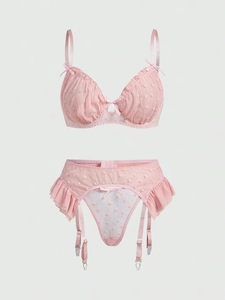 Detailed view of pink mesh bra set with heart patterns, lace ruffles and bow details