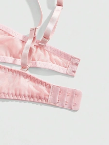 Close-up of pink mesh bra featuring a three-row hook and eye closure and adjustable straps