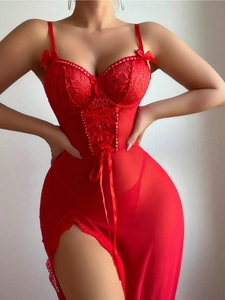Dettaglio di un body sexy in pizzo rosso con pannelli in rete velata e fiocchetti