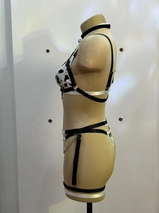 Detail view of cow print sexy lingerie set featuring halter top and black garter straps