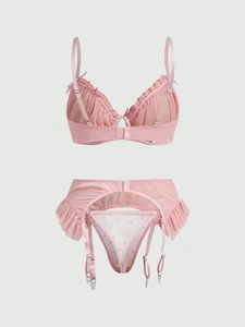 Detailed flat lay of pink mesh lingerie set featuring frill trim and heart embroidery