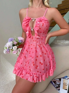 Detail of pink lingerie dress showing cherry print, ruffled V-neck and heart-shaped buckles
