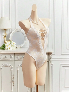 Close-up of white floral lace teddy with deep V-neckline and rhinestone cross-strap detail