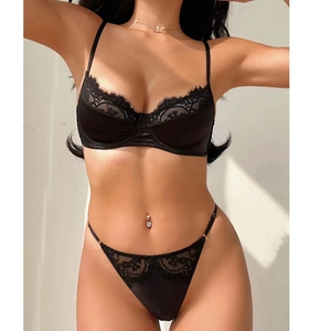 Detail of black lace lingerie set featuring eyelash trim bra and matching thong with gold jewelry