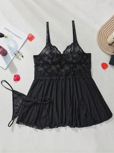 Detailed flat lay of black lace and mesh chemise with matching thong and rose petals