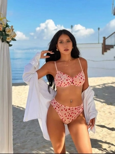Dettaglio di un set di lingerie rosa con stampe a cuore rosso e bordi con volant