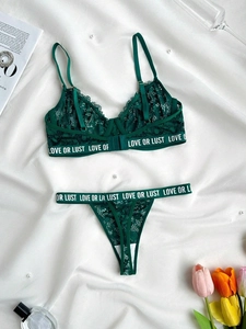 Détail d'un ensemble de lingerie en dentelle vert foncé avec texte LOVE OR LUST à la taille
