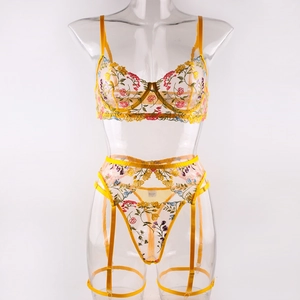 Detail of yellow floral embroidery on sheer mesh lingerie with adjustable garter straps