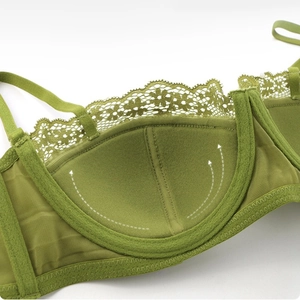 Macro view of green lace bra cup padding showing functional lift and mesh texture details