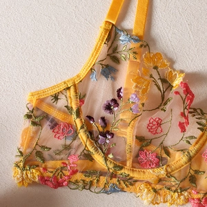 Detailed close-up of yellow floral embroidery and sheer mesh on wired lace bra