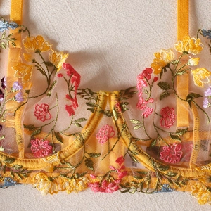 Close-up of yellow sheer mesh bra featuring colorful floral embroidery and adjustable straps