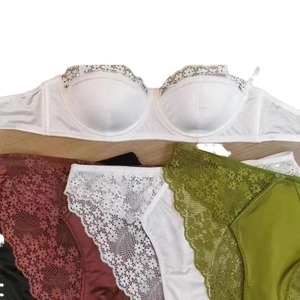 French style white lace bra with assorted floral lace panties on a wooden surface